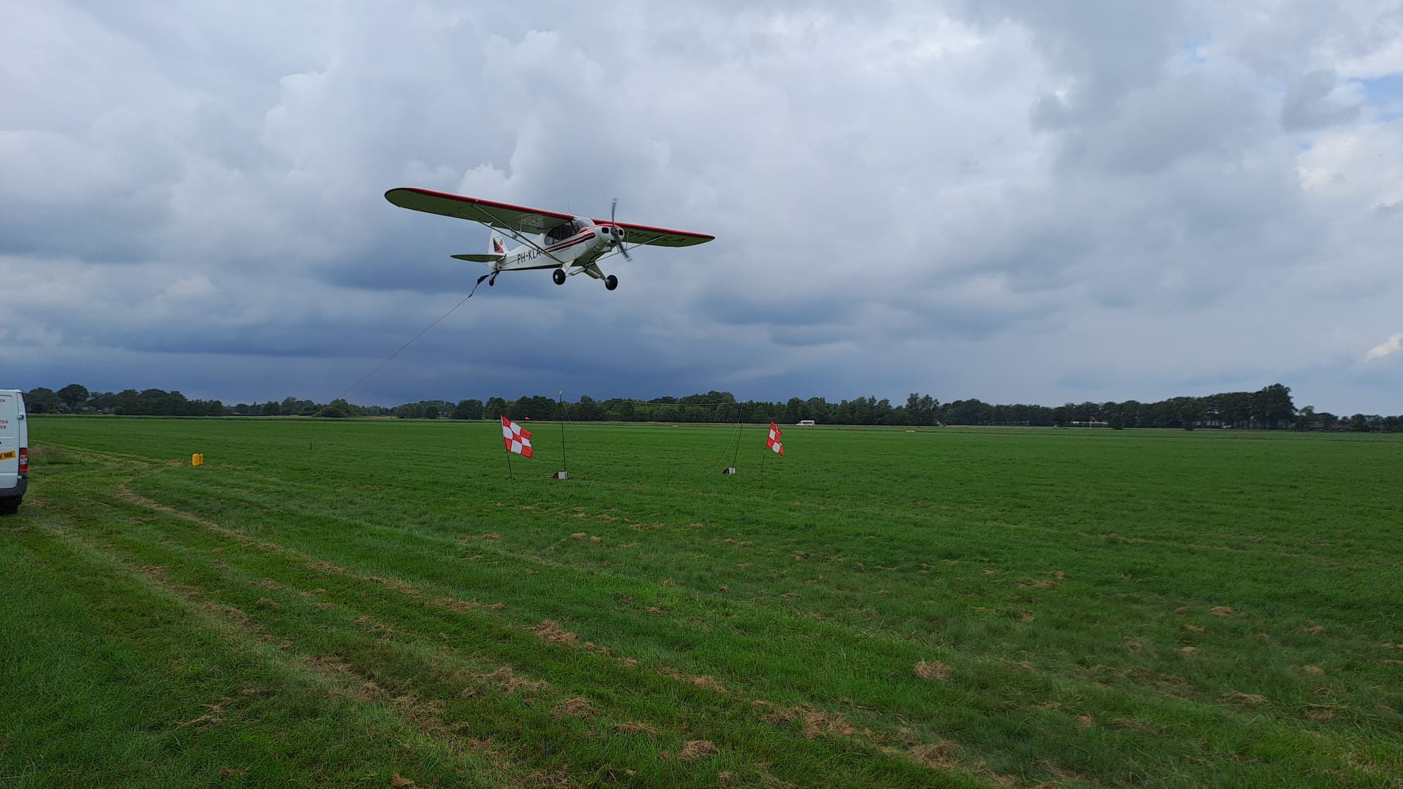 Oppikken van luchtreclame bij Special Air Services in Teuge door een Piper Super Cub met registratie PH-KLA